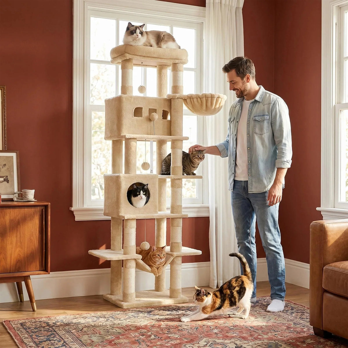 Arbre à chat 210 cm beige dans un séjour, un homme tendant la main vers un chat perché
