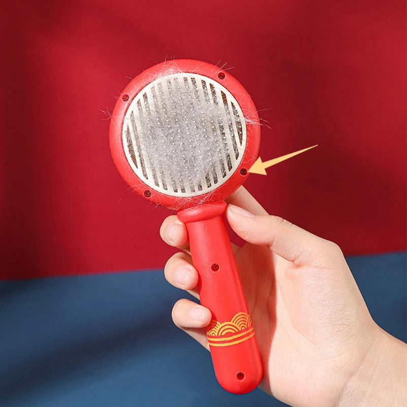 Brosse à picots pour chat tenue en main, poils regroupés sur la tête ronde avant éjection
