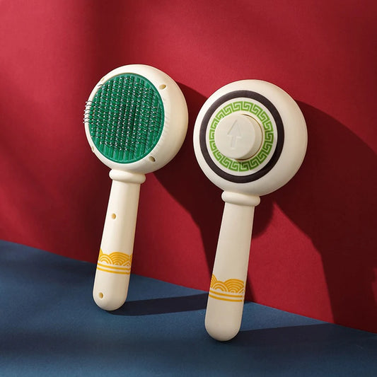 Brosse à picots pour chat coloris beige, tête ronde et manche à motif, posée sur fond rouge et bleu