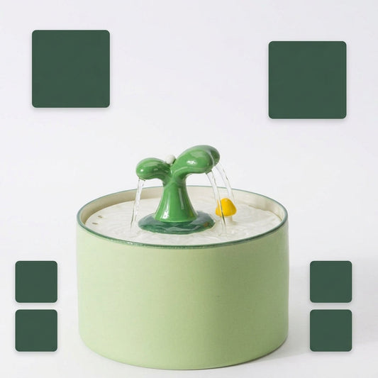 Fontaine à eau chat céramique verte, bec en pousse et deux filets d'eau sur galet jaune