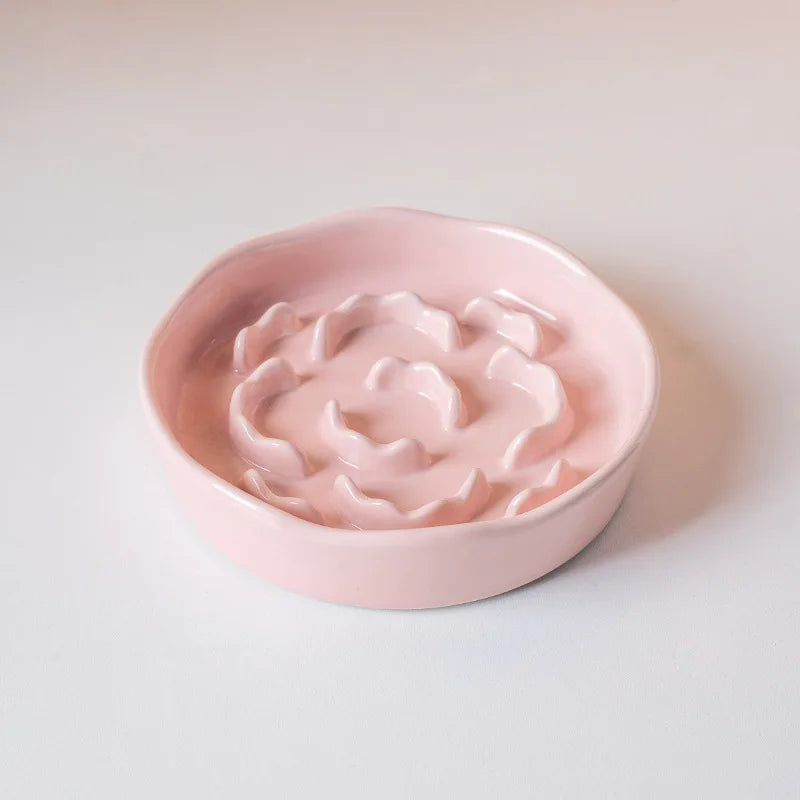 Gamelle rose pâle en céramique à bord ondulé et reliefs en pétales, vue de trois quarts — gamelle anti glouton chat