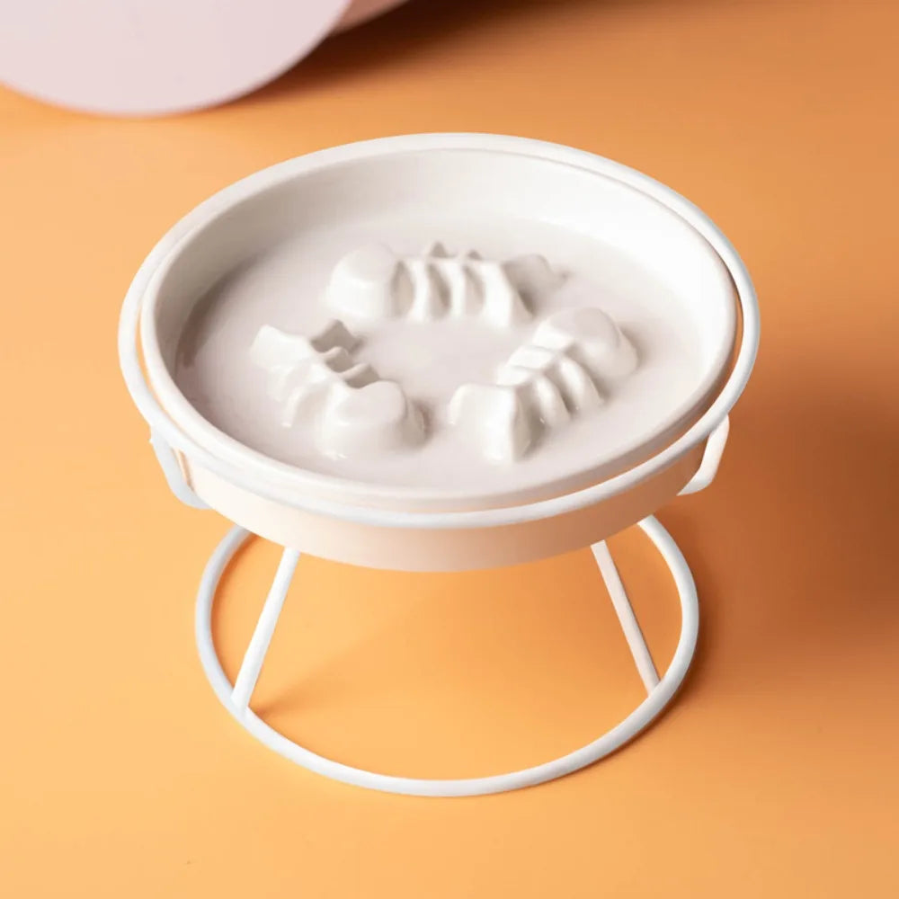 Bol blanc en céramique à reliefs sur son pied en métal blanc, vu de trois quarts — gamelle anti glouton chat