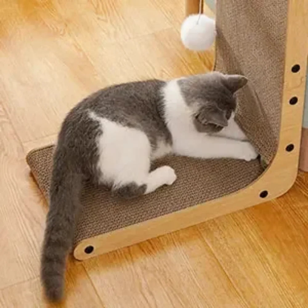Chat gris et blanc couché sur le plateau bas du griffoir chat design, pompon suspendu au-dessus