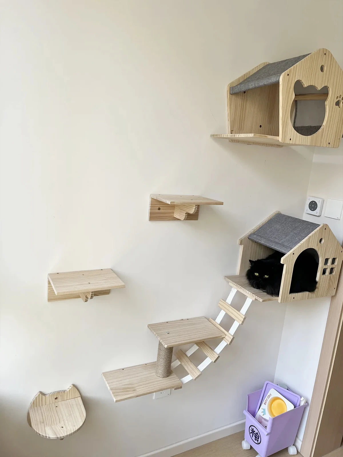 Maisonnette murale en bois à toit feutré, chat noir couché dans l'ouverture ronde — maisonnette murale pour chat